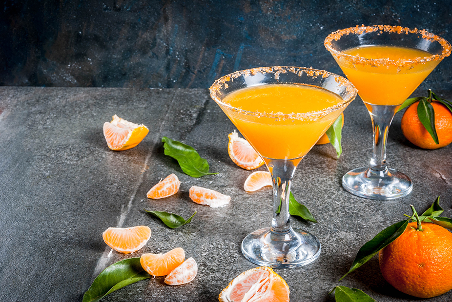 Recipes and ideas of winter fruit cocktails, Tangerine martini margarita with fresh tangerines, on dark background, copy space