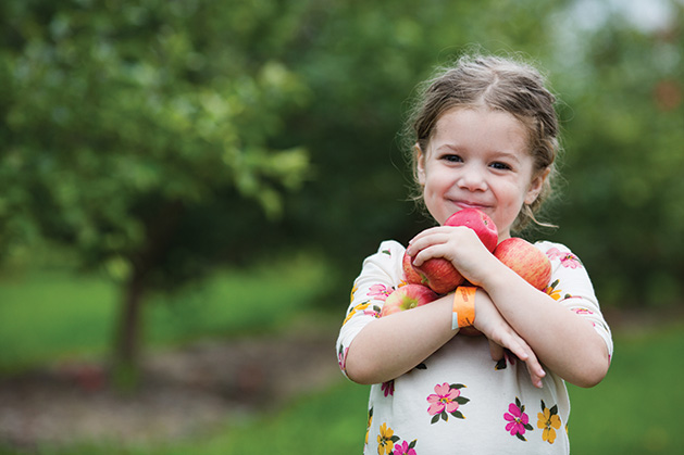 A girl holds some apples at Apple Jack Orchards