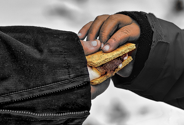 Two hands hold a smore.