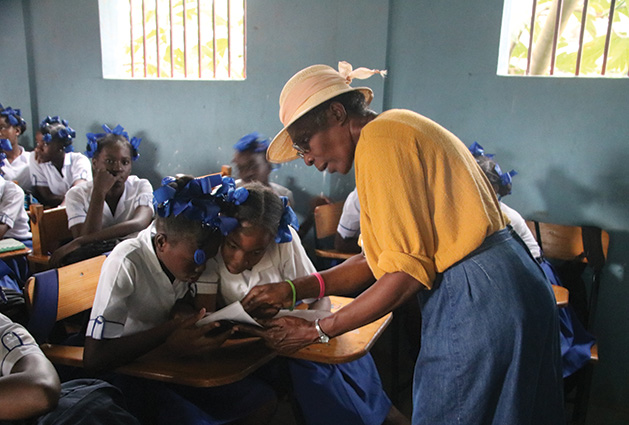 A representative of Days for Girls teaches Haitian girls about menstrual hygiene products.