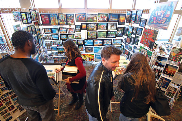 Patrons browse a booth at the Plymouth Arts Fair.