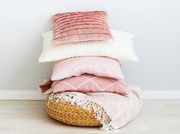 Stack of pink and white velvet throw pillows.