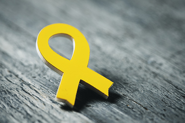 A yellow ribbon pin, signifying support for veterans.