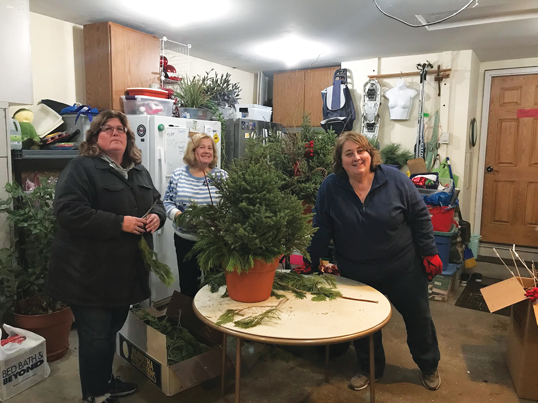 Members Christie Salonek, Lin Juntti and Sarah Colpitts assemble spruce tip pots for the Waytonka Club 2022 Fall/Winter Marketplace fundraiser.