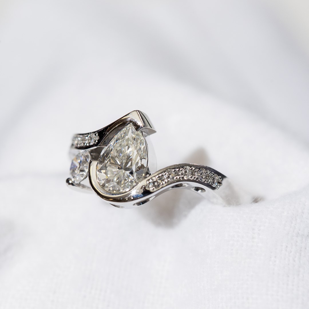 A flowing platinum band accentuates the pear-shaped diamond in Gay’s ring.