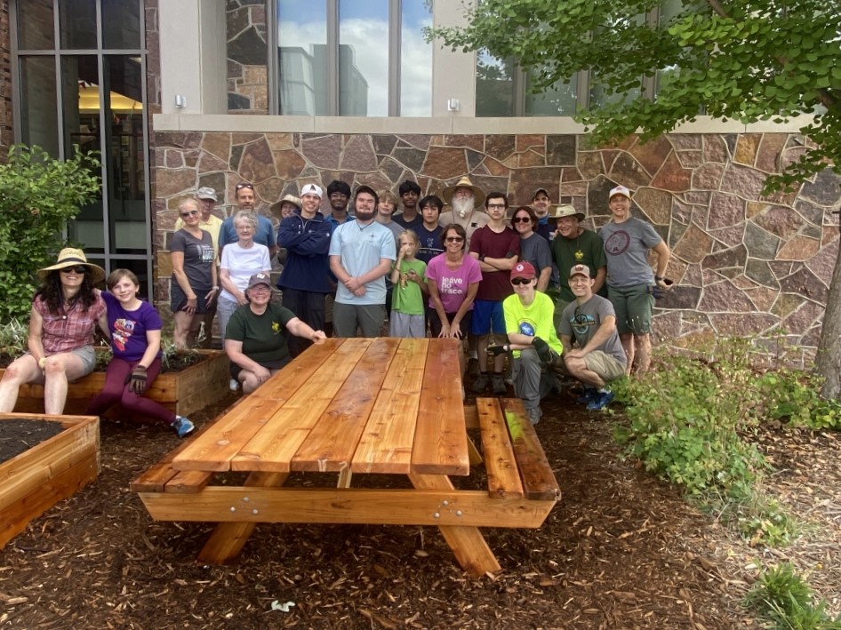 CJ Schempp (middle left, wearing dark blue) and Cameron Rhoads (middle right, wearing light blue) pose in front of the picnic table that was part of Cameron's Eagle Scout project.