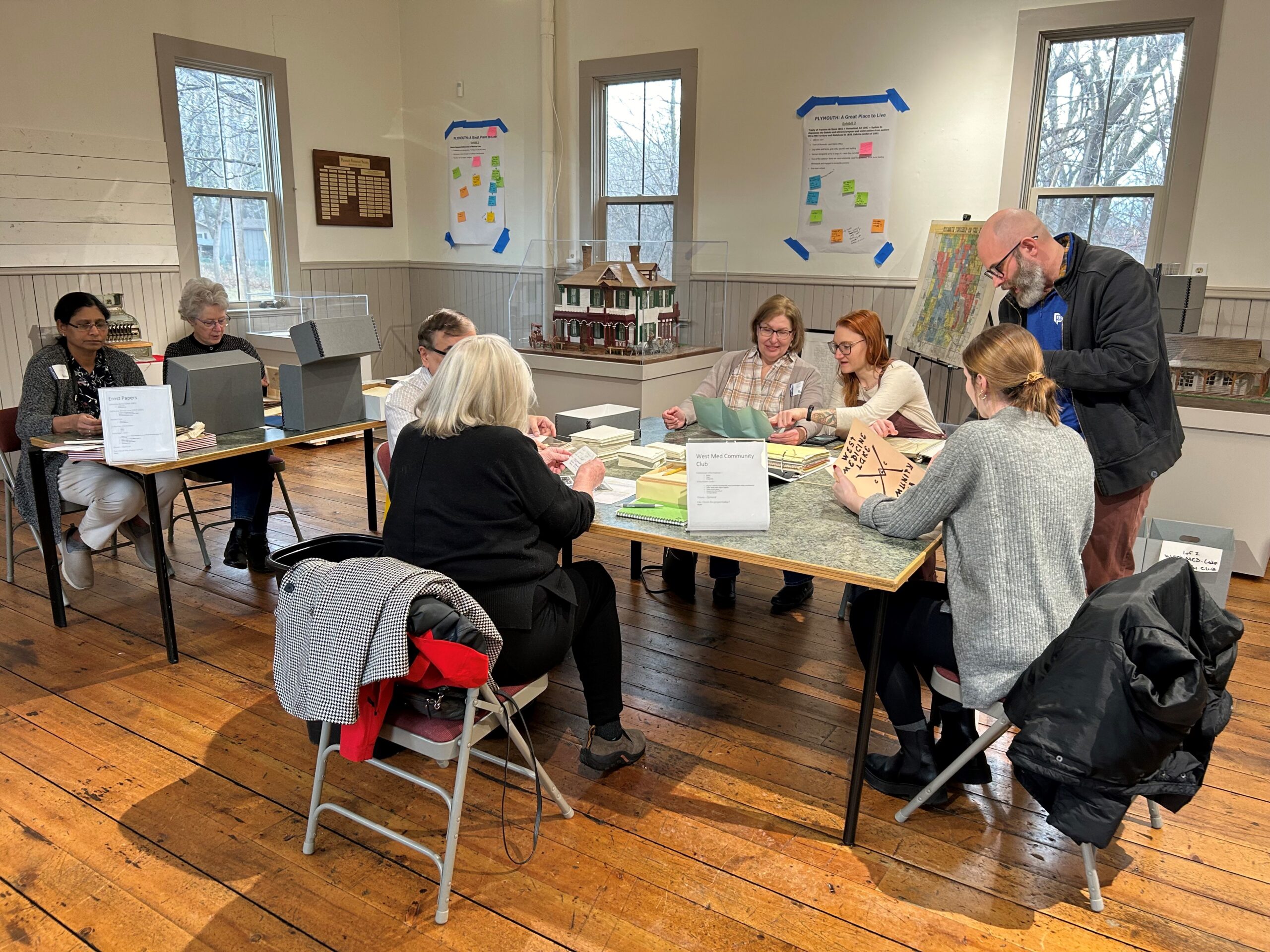 A group of volunteers help Plymouth staff archive historic artifacts.