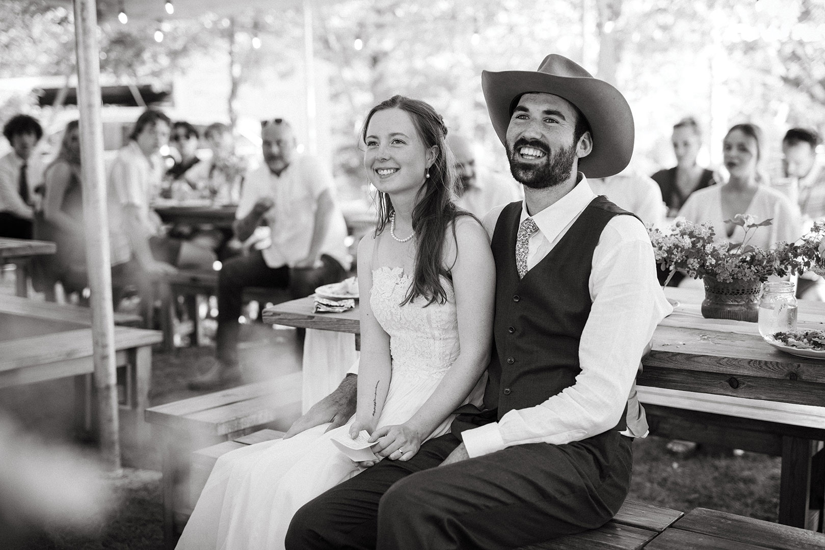 The bride’s vintage dress was purchased and altered at Sienna Cole Bridal. Owner Lisa Ramlet replaced the original skirt with a flowy, organic fabric. The look was balanced with her great-grandmother’s pearl jewelry, secondhand clogs and a blusher veil (also from Sienna Cole). The groom’s brown, three-piece custom suit from Milbern Clothing Co. was inspired—in fit, style and material—by 1930s cinema stars like Jimmy Stewart. An acorn-patterned tie and boots from Red Wing Shoes completed the look.