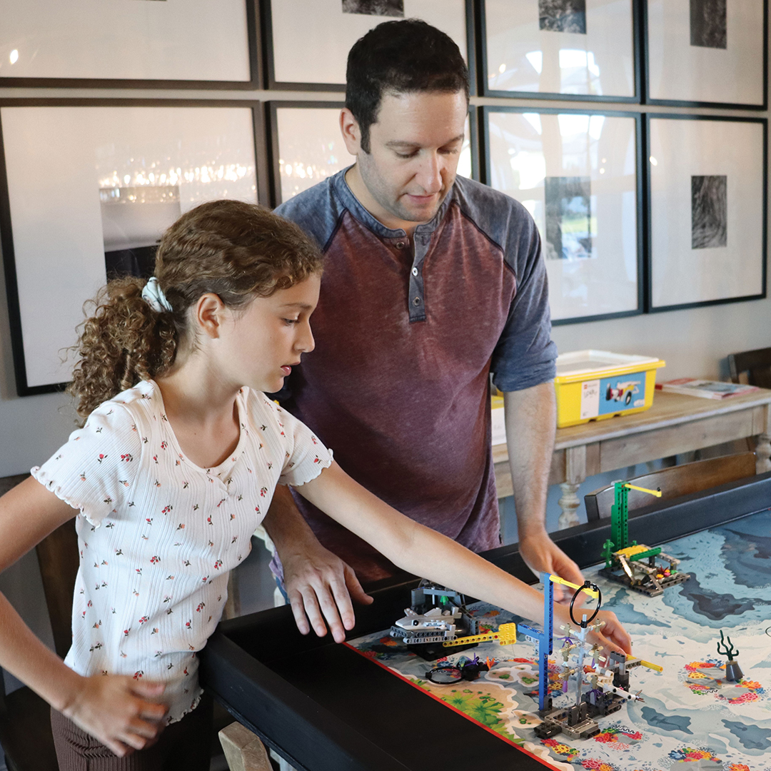 Brian and Allie Martell work on the First Lego League competition board together.