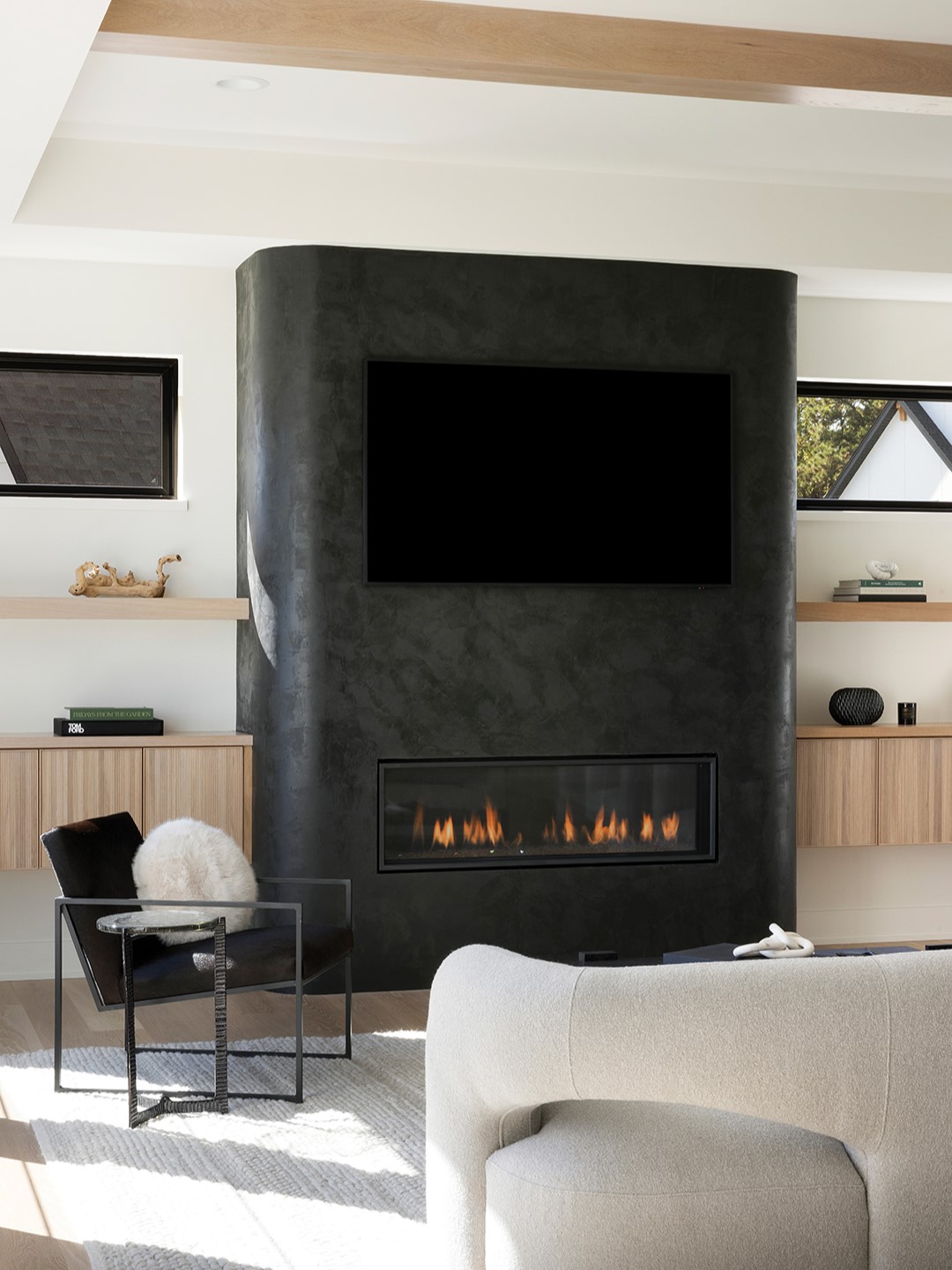 This 8-inch radius cornered fireplace is painted in Roman Clay’s Fade to Black. “We had never fully painted a fireplace in this Roman Clay brand or this color before,” Lindsey Swanson says. The high contrast grounds the space while adding an interesting focal point to the living room.