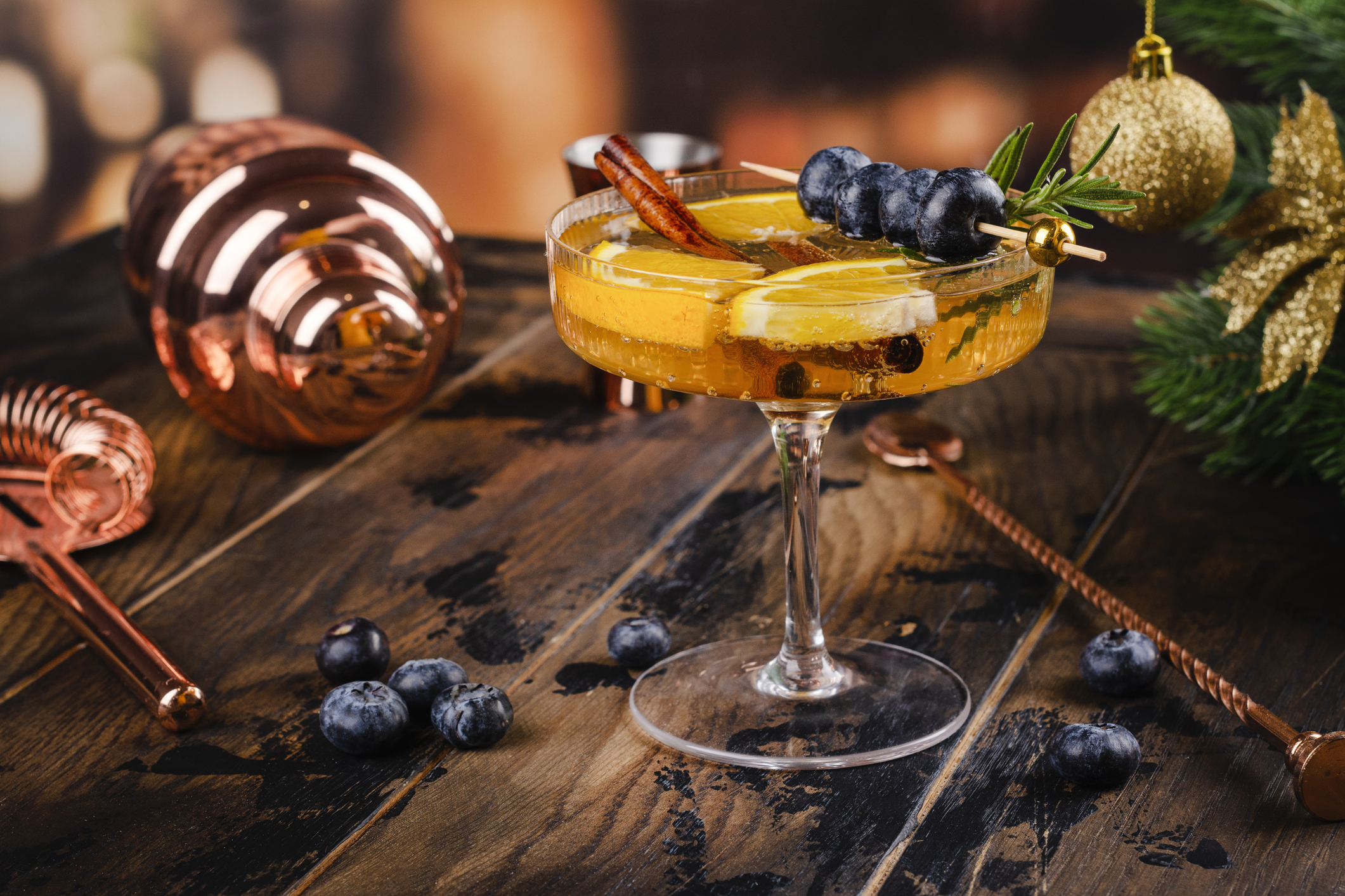 Christmas cocktail with cranberry, rosemary and blueberry over new year festive background. Copy space