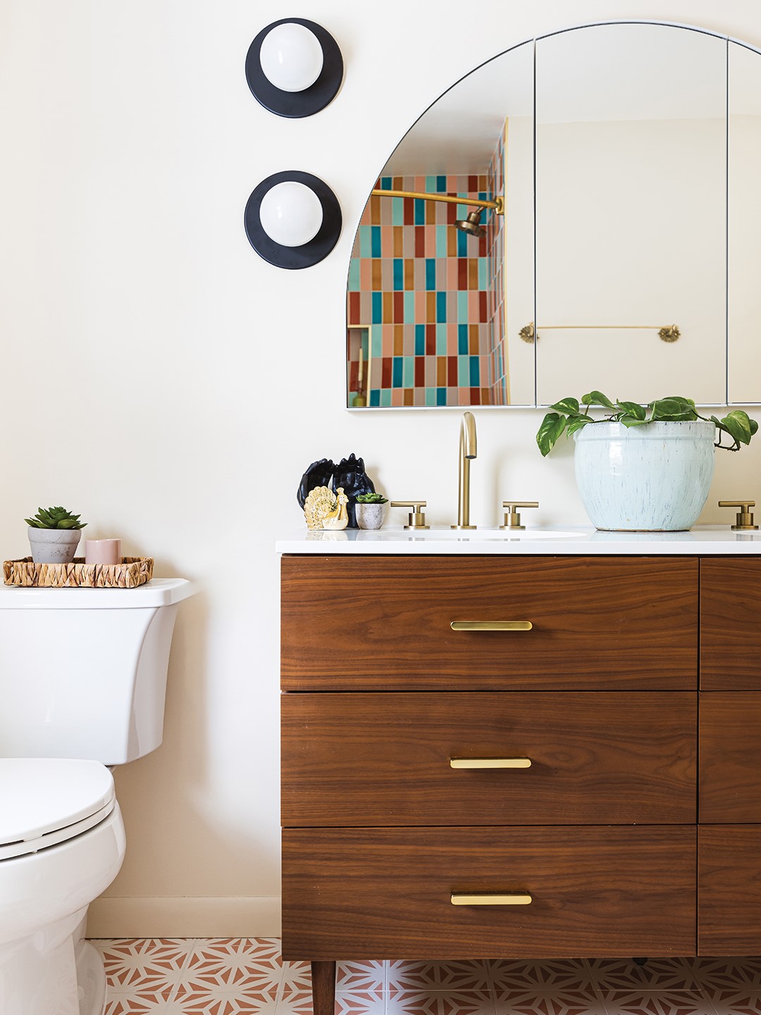 It was an instant “yes” when Taylor Morrill and her husband, Declan McCrory, first saw these globe lights. Moonstone Design & Build’s founder, Lidia Valdivia, designed the asymmetrical fixture for the bathroom vanity to ground the room while also creating visual interest.